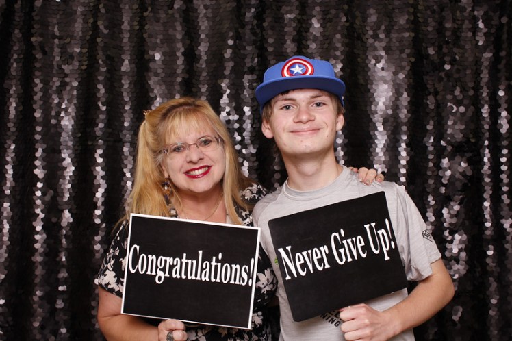 Tim and mama smiling black belt   with signs sept 2019.jpg